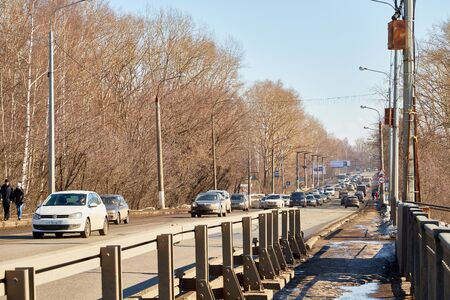 Kirov, Russia - March 23, 2019: Car on the dirty road in Russia in a spring day. Spring city landscape in a sunny day with blue sky with white cloudsのeditorial素材