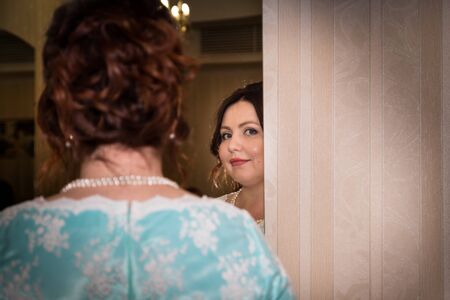 Kirov, Russia - June 15, 2018: Plump russian bride in green dress and with bouquet of flowers waiting groom in the roomのeditorial素材