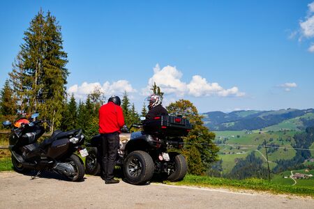 Lucerne, Switzerland - September 20, 2018: ATV car and tourists near it on the road in the mountains on a Sunny day. Beautiful mountains landcape which is very good for sportのeditorial素材