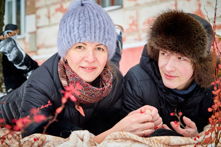 Happy PlayfulMother and adult son walking in city park in a winter dayの写真素材