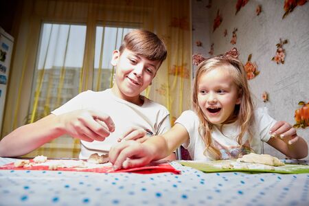 Kirov, Russia - November 04, 2018: Children brother and sister having fun with flour and dough at homein the kitchen. Cooking, fun and mischiefのeditorial素材