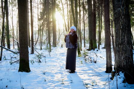 Plump woman in a nice winter forest full of snow. Lady in fur coatの写真素材