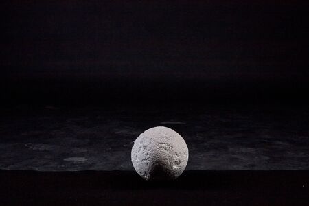 White ball of foam on a black background in the Studio and empty arround