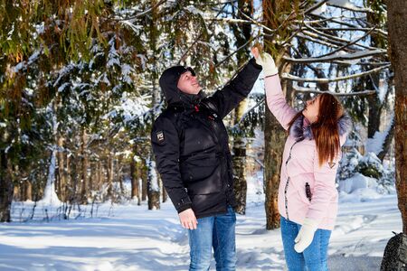 Kirov, Russia - February, 23, 2019: Happy Young Couple having fun in Winter forest. Family Outdoors. Love, fun, season and people - walking in winter parkのeditorial素材