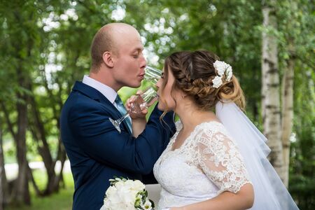 Russian bride and groom together in the green city park
