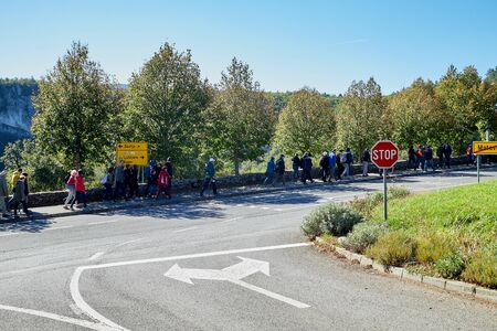 Slovenia, Koper - September 26, 2018: large group of travelers walking along the road in the forest...
