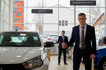 Kirov, Russia - February 26: Male managers and cars Lada in showroom of dealership Autovaz in Kirov...