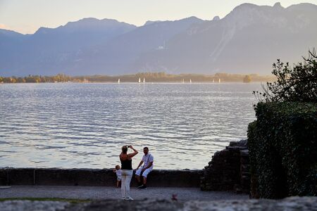 Geneva, Switzerland - September 20, 2018: Tourists on the beach of lake at sunset in a summer eveningのeditorial素材