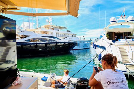 Saint-Tropez, France - September 23, 2018: Yachts at sea and people on the pier near them on a Sunny day. Ships and blue sky with white clouds at the resort placeのeditorial素材