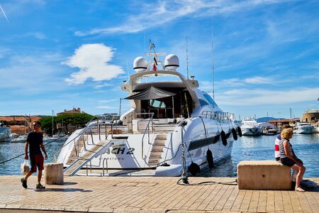 Saint-Tropez, France - September 23, 2018: Yachts at sea and people on the pier near them on a Sunny day. Ships and blue sky with white clouds at the resort placeのeditorial素材