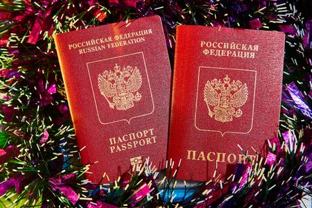 Colorful Christmas tinsel and two passports of of citizen of Russia. The concept of traveling abroad in the New yearの写真素材