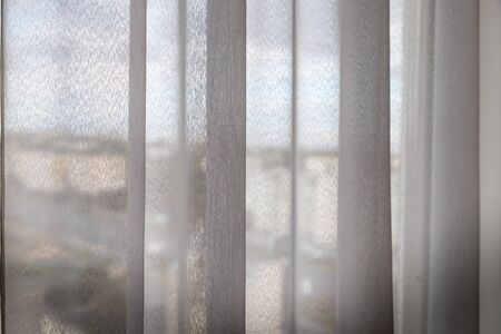Transparent white curtain on the window and city behind it. Curtain backgroundの写真素材