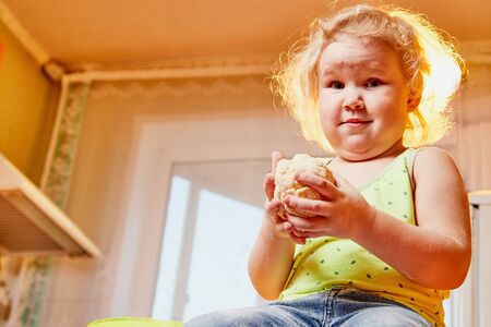 Emotional Small girl with the dough in the kitchen on the table. Funny photoshootの写真素材