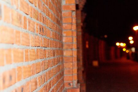 Red brick wall outside in the dark at night. Picture for texture or backgroundの写真素材
