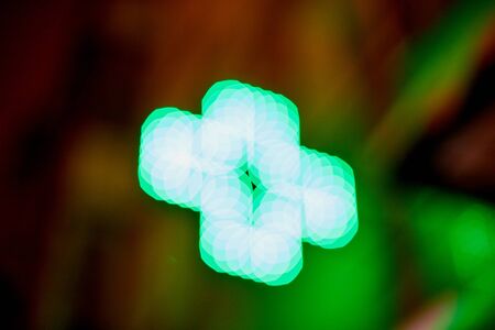 Abstract texture with light blurred cross and black background in a nightの写真素材