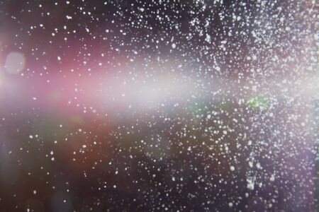 Abstract white blurred dust explosion and flash with illumination on a black backgroundの写真素材