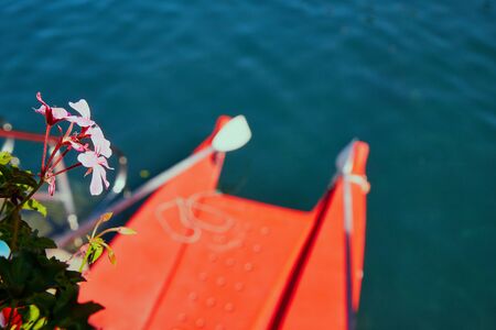 Board the red boat in the water of the lake in a nice Sunny summer dayの写真素材