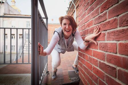 Brunette girl on the roof in the Central part of the old city. Walk in downtown. Portrait of a funny pretty girl in the town. Bottom viewの写真素材