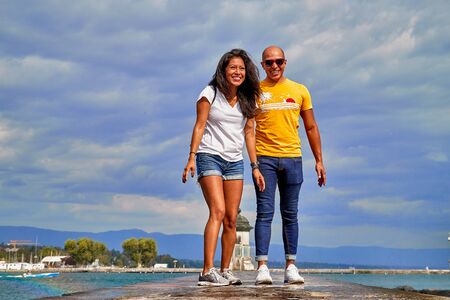 Geneva, Switzeland - September 21, 2018: Geneva, Switzeland - September 21, 2018: Tourisths on embankment near famous fountain on lake Geneva in a nice day with blue sky and clouds in summerのeditorial素材