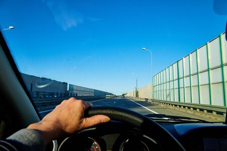 Zakopane, Poland - September 29, 2019: Track from the car window and blue sky. Woman's hand on the steering wheel. Female driver seeing beautiful landscape during travel in autoのeditorial素材