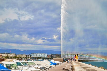 Geneva, Switzeland - September 21, 2018: Pier near famous Jet d'Eau fountain in Geneva lake and tourists on it in a nice day with blue sky and clouds in summer, Canton of Geneva, Switzerlandのeditorial素材