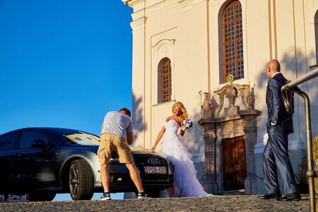 Tihany, Hungary - September 27, 2019: Photo shoot of a wedding couple near the castle. Shooting the bride and groom by a male photographer on their wedding dayのeditorial素材