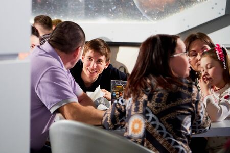 Kirov, Russia - April 18, 2019: People at table in cafe or restaurant discussing something during...