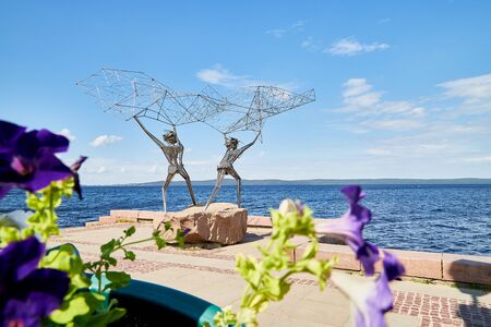 PETROZAVODSK, RUSSIA - JUNE 19, 2019: Sculpture on the embankment of the city of Petrozavodsk in Karelia in Russia on a Sunny summer day. Iron fishermen with a fishing netのeditorial素材