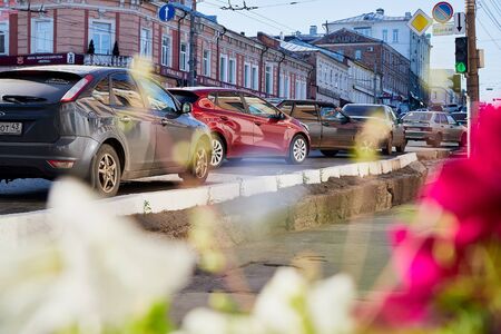 Kirov, Russia - July 16, 2019: Street with cars and flowers in provincial city Kirov on a sunny...
