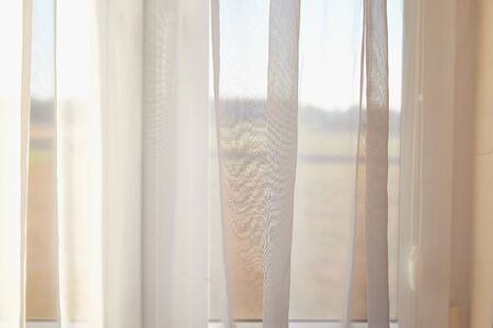 Transparent white curtain on the window and nature behind it. Curtain background