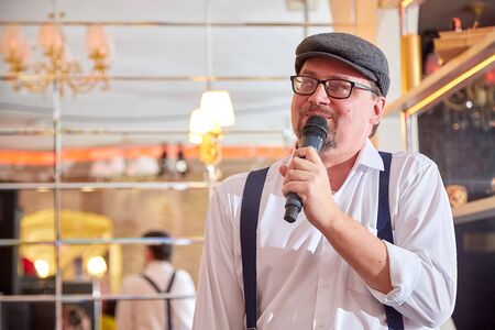 Kirov, Russia - October 10, 2019: Actor performing with microphone in small cafe or restaurant. Handsome manのeditorial素材