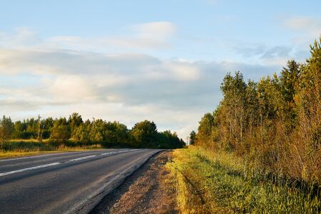 Road panorama with with sunny sky and tree in summer, autumn or spring evening. Travel background. Highway in nature landscape. Trip in holidayのeditorial素材