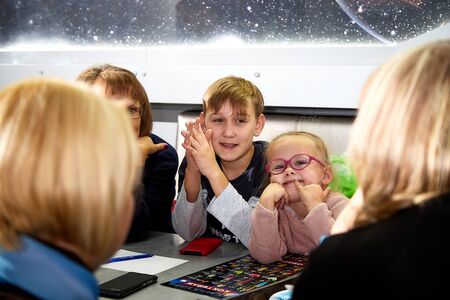 Kirov, Russia - September 25, 2019: People at table in small cafe or restaurant during intellectual game. Hungry group waiting for the waiter to get the menu or foodのeditorial素材