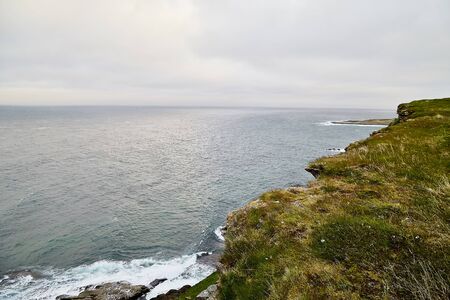 Norway landscape with rocky shore of the Northern sea in cloudy weather in a summer, spring or autumn dayの写真素材