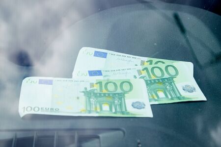 Euro banknotes on the black dashboard and their reflection in the windshield inside of a carの写真素材