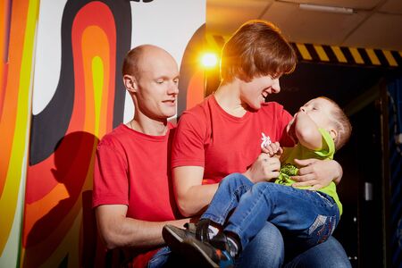 Kirov, Russia - August 11, 2019: Happy family with mother, father, and son in intresting place full of drawing and graffiti. Mom, dad and boy indoors with pictures on the wallのeditorial素材