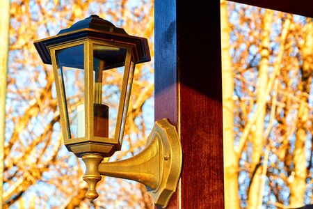 Streetlight on yellow wooden gazebo on a Sunny winter day with blue sky. Lattern and wooden plankの写真素材
