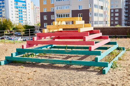 Sand with wooden pyramid with steps which is playground equipment on a public playground in yard...