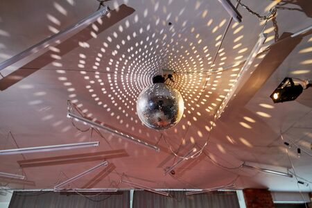 Disco ball with mirror and light on the celling. Background. Close up