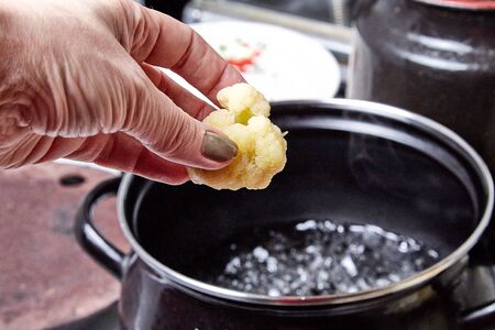 Cooking. Broccoli and a black bowl of boiling water on the stoveの写真素材