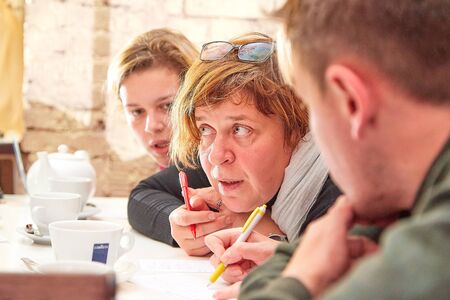Kirov, Russia - October, 2019: People at table in small cafe or restaurant during intellectual game. Hungry group discussing the menu in the restaurant and waiting for the waiter to get foodのeditorial素材
