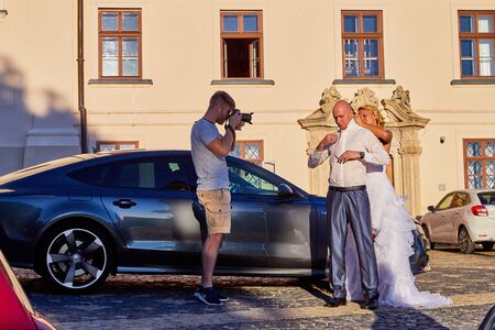 Tihany, Hungary - September 27, 2019: Photo shoot of a wedding couple near the castle. Shooting the bride and groom by a male photographer on their wedding dayのeditorial素材