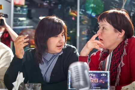 Kirov, Russia - September 25, 2019: People at table in small cafe or restaurant during intellectual game. Hungry group discussing the menu in the restaurant and waiting for the waiter to get foodのeditorial素材