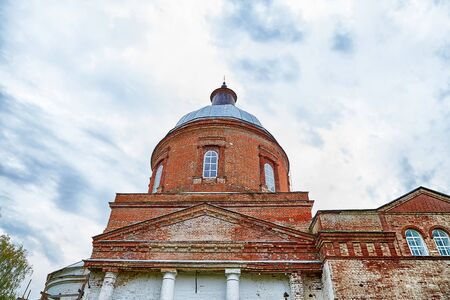 Traditional russian church with domes is made of red brick and sky background in a cloudy day....