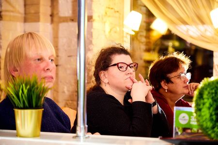 Kirov, Russia - September 17, 2019: People at table in small cafe or restaurant during intellectual game. Hungry group waiting for the waiter to get the menu or foodのeditorial素材