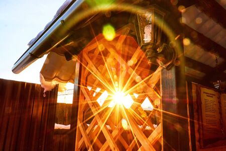 Shine of a sun through the wooden rail and bars of the yellow gazebo in a day or eveningの写真素材