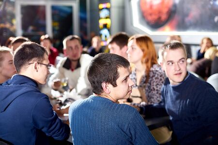 Kirov, Russia - September 25, 2019: People at table in small cafe or restaurant during intellectual game. Hungry group waiting for the waiter to get the menu or foodのeditorial素材