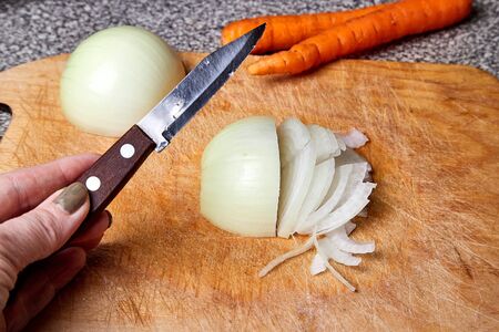 Preparation of carrots and onions for cooking. Slicing into piecesの写真素材