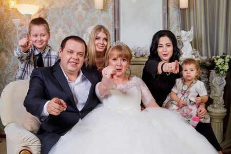 Russia, Kirov - January 24, 2019: Bride and big fat groom after wedding and marriage registration having photoshoot with guests and relatives in registry officeのeditorial素材
