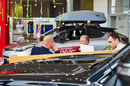 Murmansk, Russia - June 21, 2019: Managers in showroom with cars of dealership Toyota in Murmansk...
